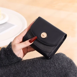Dettaglio del portafoglio nero in pelle PU con tessuto grigio e chiusura girevole