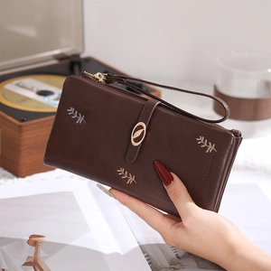 Détails de broderie de feuilles et boucle métallique sur portefeuille marron
