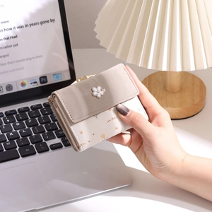 Détail du portefeuille compact à trois volets avec fermoir fleur et imprimé tulipe doux