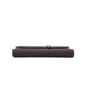 Détail de la pochette en cuir grainé marron foncé avec boucle en métal or rose