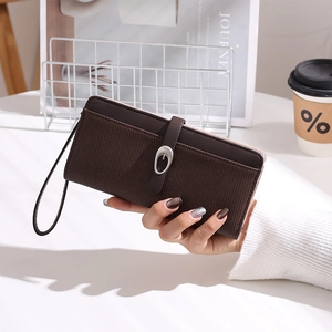 Detailed view of deep brown long wallet with metallic buckle and striped texture