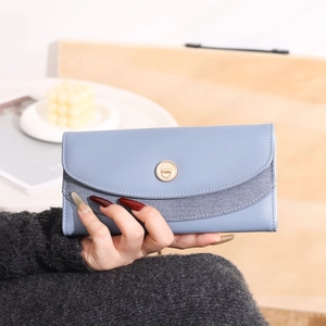 Dettaglio del portafoglio blu in pelle PU con fibbia dorata e inserti in tessuto a righe