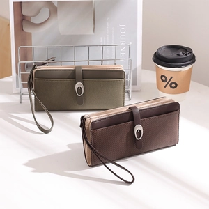 Detail of long wallets with twill texture, wrist straps and metal buckles on white desk