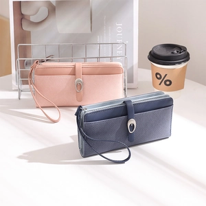 Detail of faux leather long wallet with textured stripes and decorative metal buckle strap