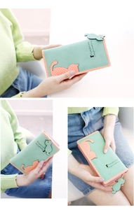 Detail of mint green long wallet featuring cute cat patch and pink zipper pull