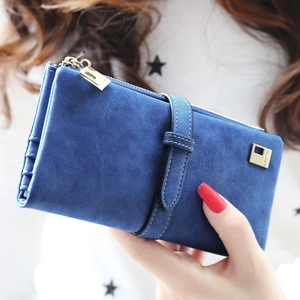 Close-up of sapphire blue matte leather long wallet with gold hardware in hand