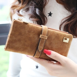 Detail view of a long frosted brown leather wallet held by a model in outdoor light