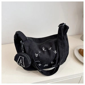 Detail of black corduroy tote bag with white embroidery and detachable round coin purse