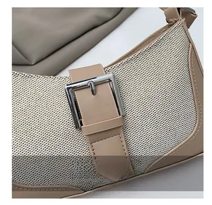 Détail de la texture patchwork en cuir beige et mesh avec boucle en métal argenté