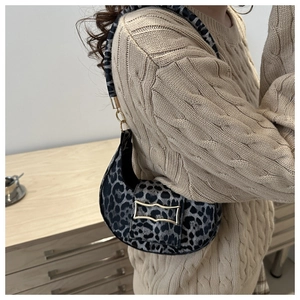 Detail of hobo shoulder bag with leopard print and gold buckle on a knit sweater