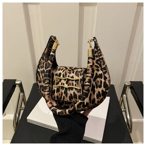 Close-up of leopard print handbag featuring a golden irregular metal buckle on faux leather