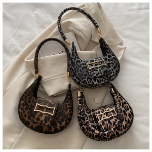 Close-up of leopard print saddle bags with gold geometric metal buckles in three colors