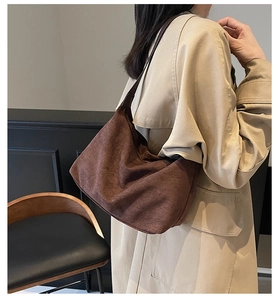 Brown suede hobo shoulder bag styled with a beige trench coat in a cozy interior
