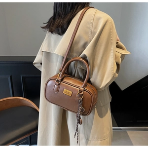 Details der braunen Vintage-Bowling-Tasche mit goldenen Beschlägen und Anhänger