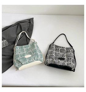 Detailed view of green and black woven plaid bucket bags with smooth leather trim