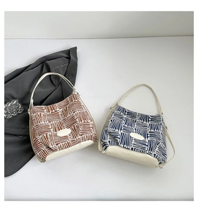 Close-up of woven tote bags in brown and navy featuring white geometric patterns