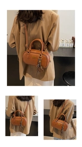 Detailansicht einer braunen Vintage-Bowlingtasche aus Leder mit Metallanhängern und Griffen