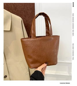 Detail view of the vintage brown soft leather mini tote bag with wrinkled texture