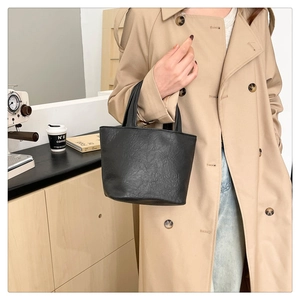 Minimalist black wrinkled leather mini tote bag with cylindrical handles for women