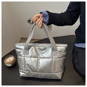 Silver quilted metallic tote bag with padded texture and grey straps for women