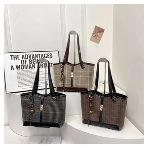 Three elegant vintage plaid wool tote bags with leather trim on white pedestals