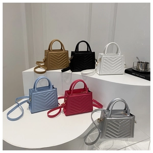 Detail of multi-color ladybags with V-quilted texture on geometric display stands