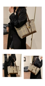 Close-up of large plaid tote bag featuring brown leather trim and golden metal clasp