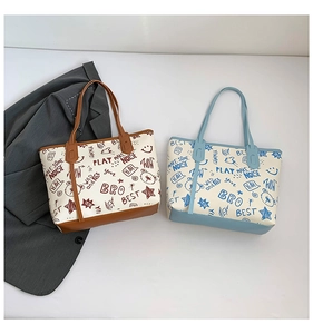 Detail view of two graffiti print tote bags in brown and blue with high-quality leather trim