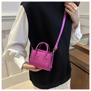 Dettaglio della mini borsa fucsia in vernice con motivo trapuntato e finiture dorate