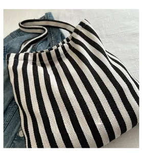 Close-up of black and white striped canvas tote bag texture on denim background