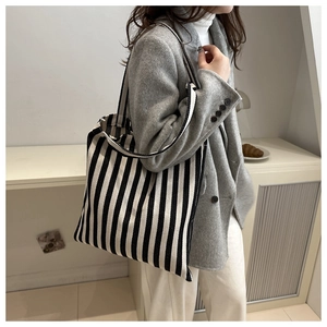 Close-up of a striped canvas tote bag showing the textured black and white vertical pattern