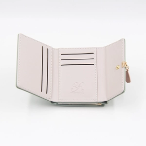 Detail view of tri-fold leather wallet showing internal card slots and leaf metal clasp