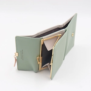 Detail view of the multi-slot interior and gold clasp on the green tri-fold wallet