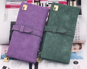 Detail of frosted suede long wallets in purple and dark green with metal buckle