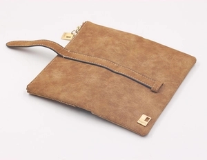 Detailed close-up of brown frosted faux suede wallet with gold zipper and wrist strap