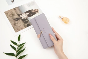 Detail view of purple PU leather long wallet featuring a rose gold leaf pendant on cover