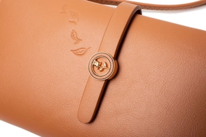 Vue détaillée du similicuir marron avec feuilles embossées et boucle rose dorée