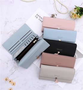 Detail view of multi-compartment long trifold wallet with leaf pendant and soft PU leather