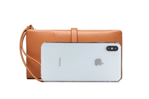 Portefeuille long en cuir marron avec feuilles embossées à côté d'un iPhone pour taille