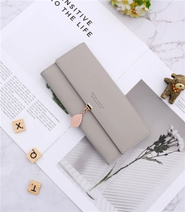 Detail of grey PU leather long wallet featuring leaf pendant and trifold flap closure