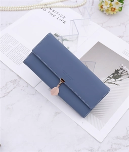 Blue long PU leather tri-fold wallet with pink leaf pendant on marble background