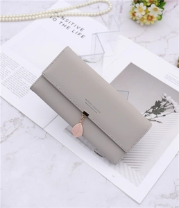Detail of light grey PU leather long wallet featuring leaf pendant and brand embossing