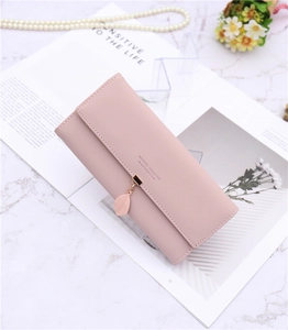Detail of dusty pink long PU leather wallet featuring a golden leaf pendant and flap closure