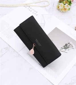 Detail of black long matte wallet with pink leaf pendant on elegant marble background
