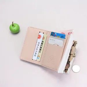 Short pink and white tri-fold leather wallet with leaf charm and zipper coin pocket