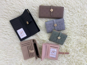 Detailed flat lay of colorful floral pattern purses on a white plush rug surface