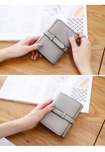 Close-up of fine grain leather texture and detailed stitching on the grey folding wallet