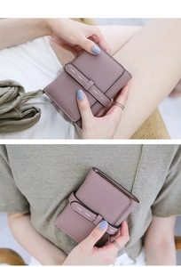 Detail of compact dusty pink faux leather wallet with contrast stitching and strap