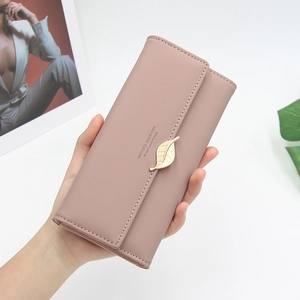 Close-up of pink long wallet with matte finish and gold leaf pendant decoration