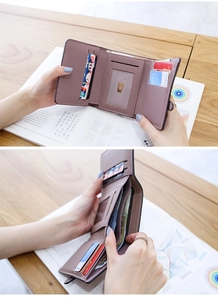 Detail view of mauve leather tri-fold wallet showing multiple card slots and ID window